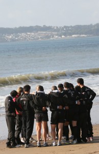 Les joueurs réunis en cercle sur la plage Swansea la concentration commence