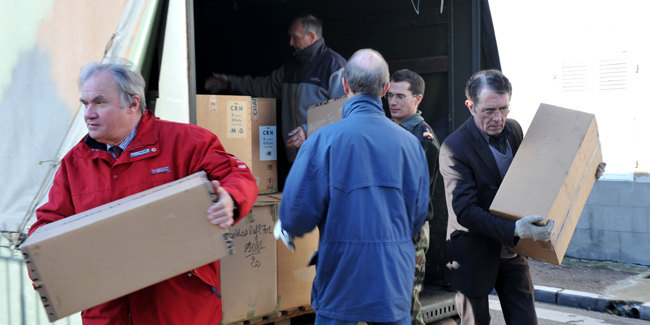 Les bénévoles anciens élèves déchargent le camion de fournitures pour l'hiver