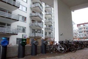 Devant des immeubles conçus pour permettre des économies d'énergie, des "tuyaux" de collectes des ordures et des vélos.