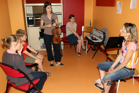 La professeur de violon explique le déroulement d'un cours à la maman de Florian