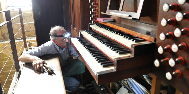 Le facteur d'orgue Philippe Emeriau travaillant sur le grand orgue de la collègiale Saint Martin